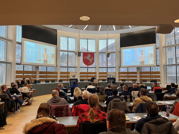 Plenum Fachtag Gewaltschutz 2025 während der Videobotschaft von Landesrat Takis Mehmet Ali