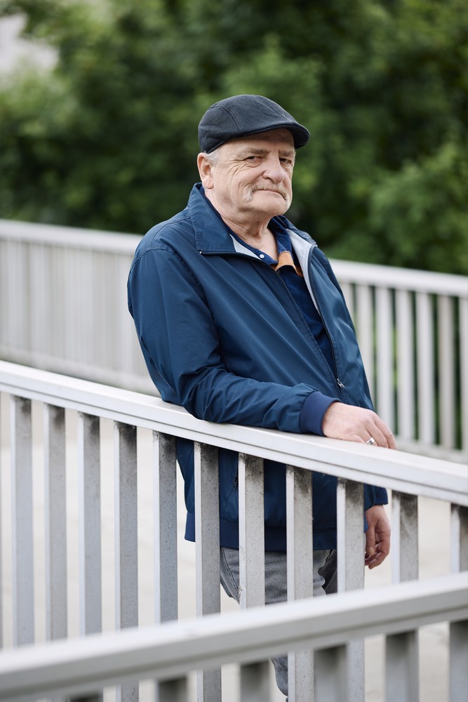 Oliver G. steht auf einer Brücke an das Geländer gelehnt