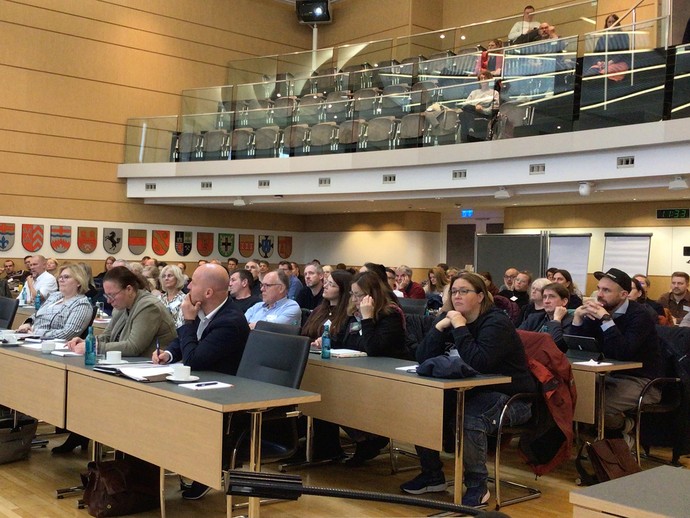 Teilnehmende im Plenarsaal (vergrößerte Bildansicht wird geöffnet)